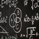 Blackboard inscribed with scientific formulas and calculations in physics, mathematics and electrical circuits. Science and education background.